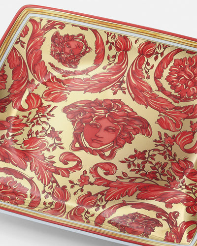 A luxury Versace Medusa Garland small porcelain bowl featuring a vibrant red finish, accented with an intricate gold acanthus leaf border and the iconic gold Medusa head emblem centered at the base.